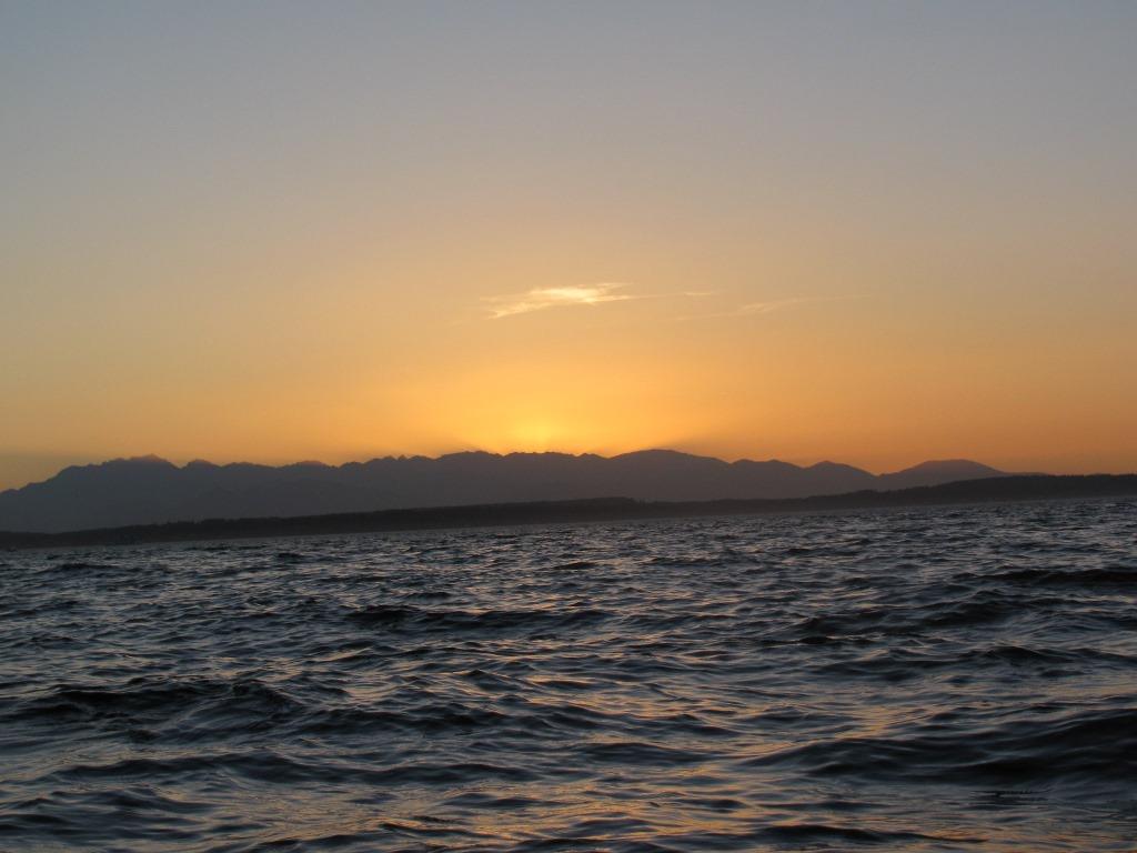 Watching the sun set behind the mountains from the water